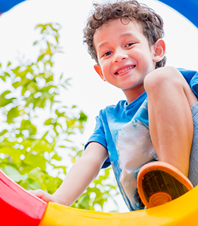Elementary school boy outside on playground equipment